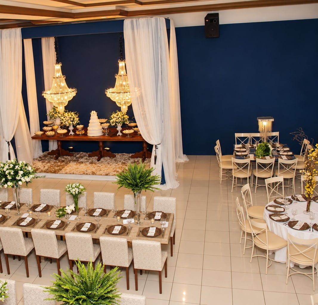 Vista do alto do salão de casamento: cortinas brancas, lustres de cristal, mesa imperial e mesas redondas postas