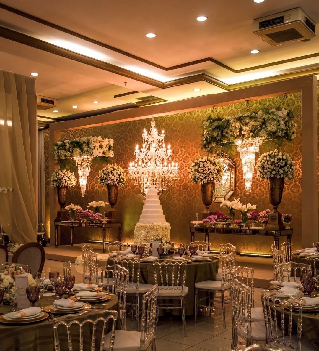 Salão do Espaço Belladata decorado para casamento, com lustre de cristal e mesas redondas